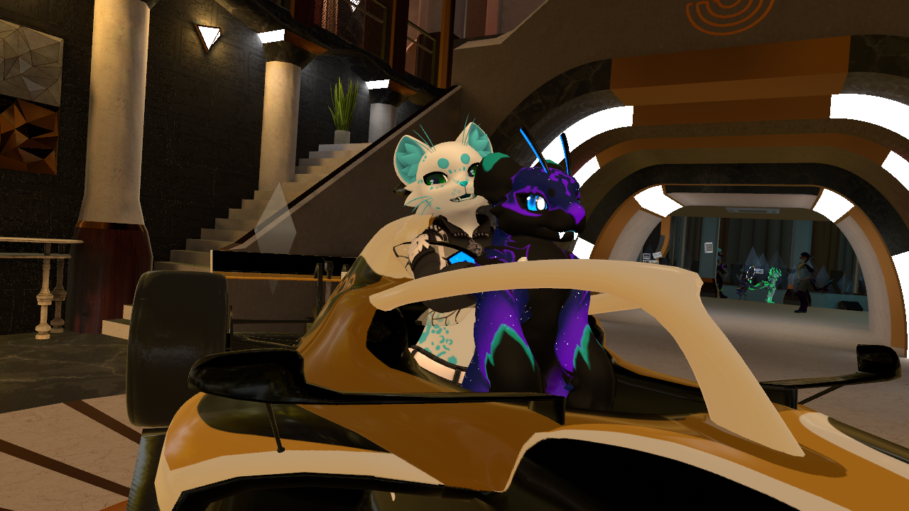 Mue holding a tigerbee pup in a formula one car.