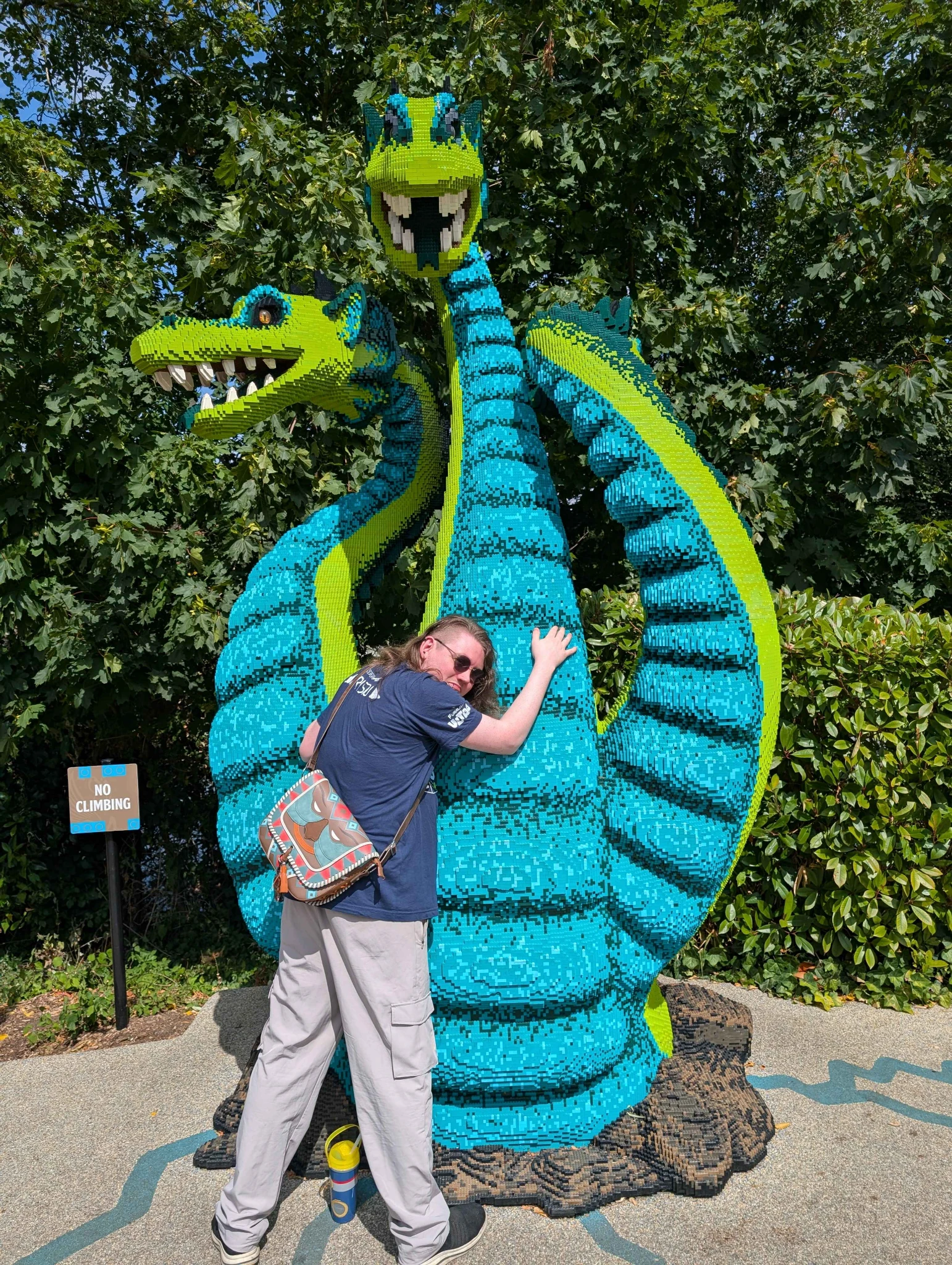 Lissy at Legoland, embracing a three-headed Lego dragon.